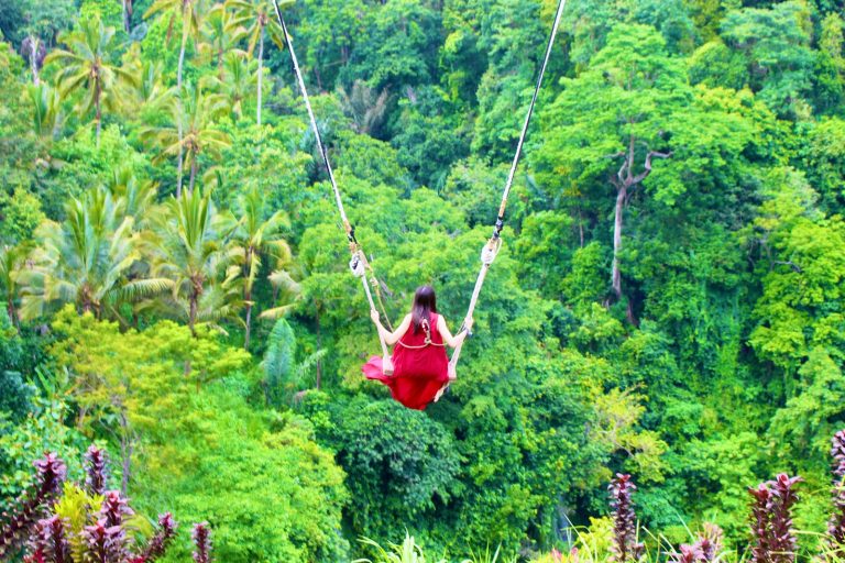 person in red jacket riding on swing